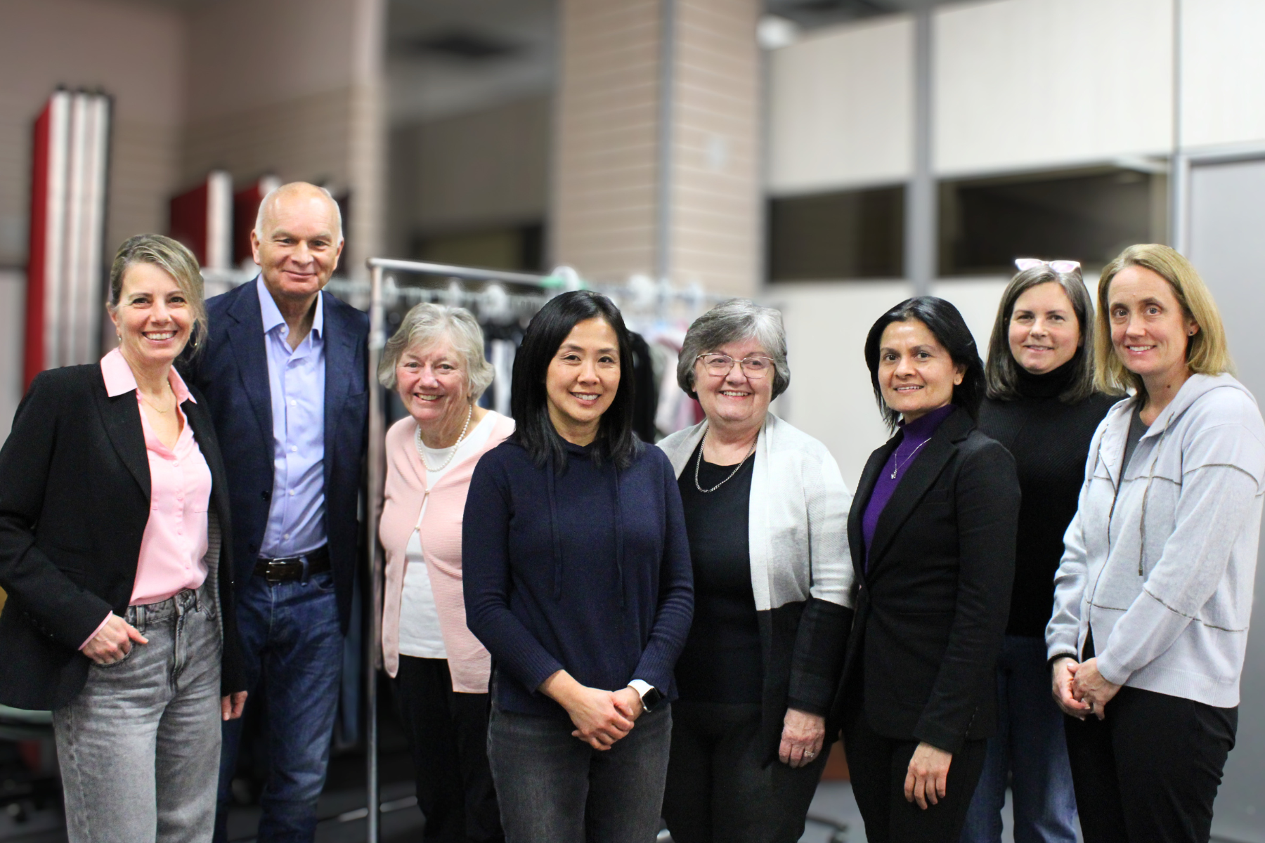 New Circle's CEO Cindy standing with a table full of donated shoes and handbags