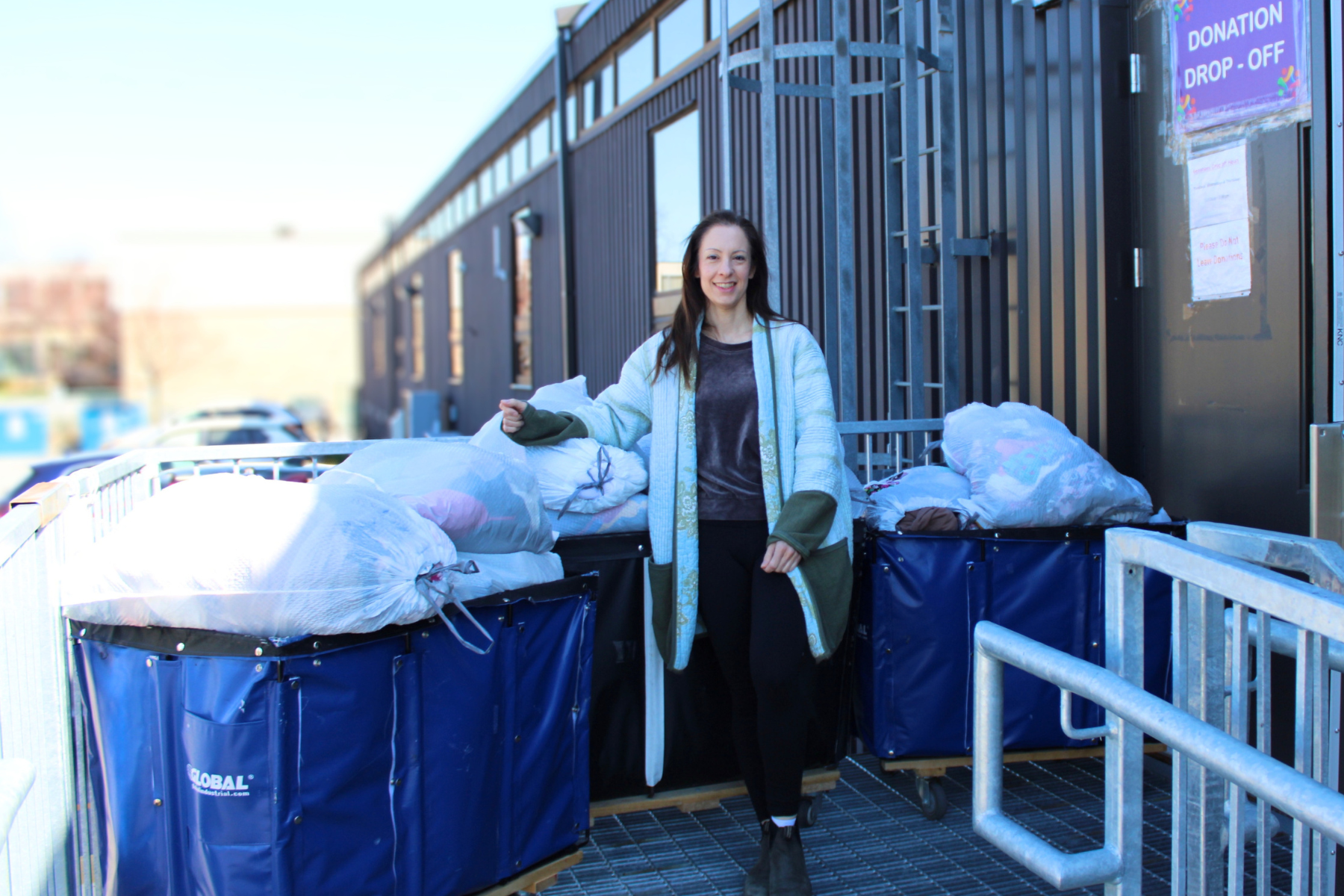 Two people holding bags, making a clothing donation.